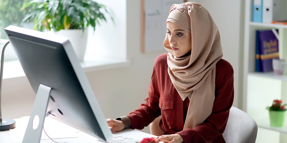 Eine Person, die im Homeoffice am Schreibtisch arbeitet