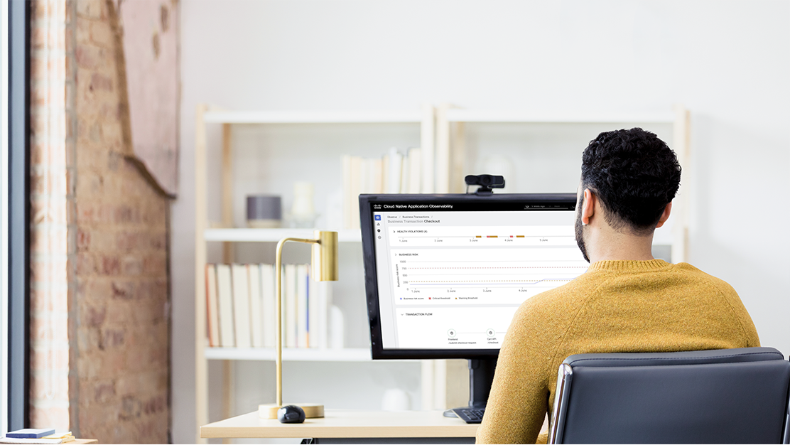 Person sitting at desktop, looking at screen with Cisco dashboard displayed